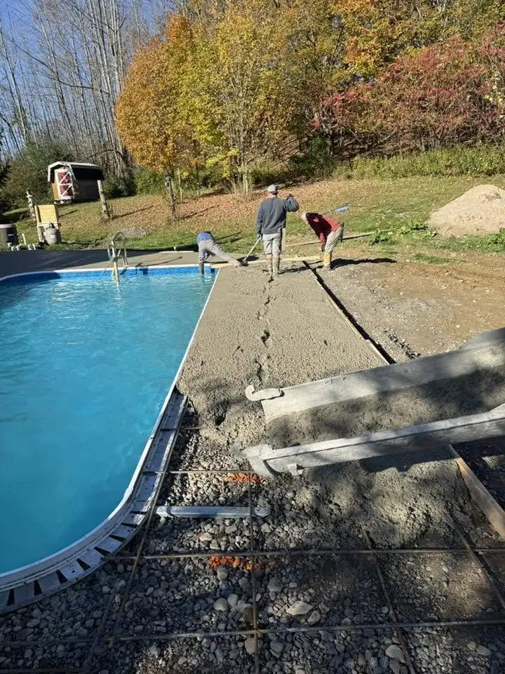 Crew finishing a concrete pool deck
