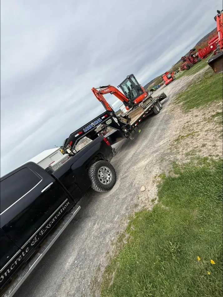Bennett's pickup towing the mini excavator on a gooseneck trailer