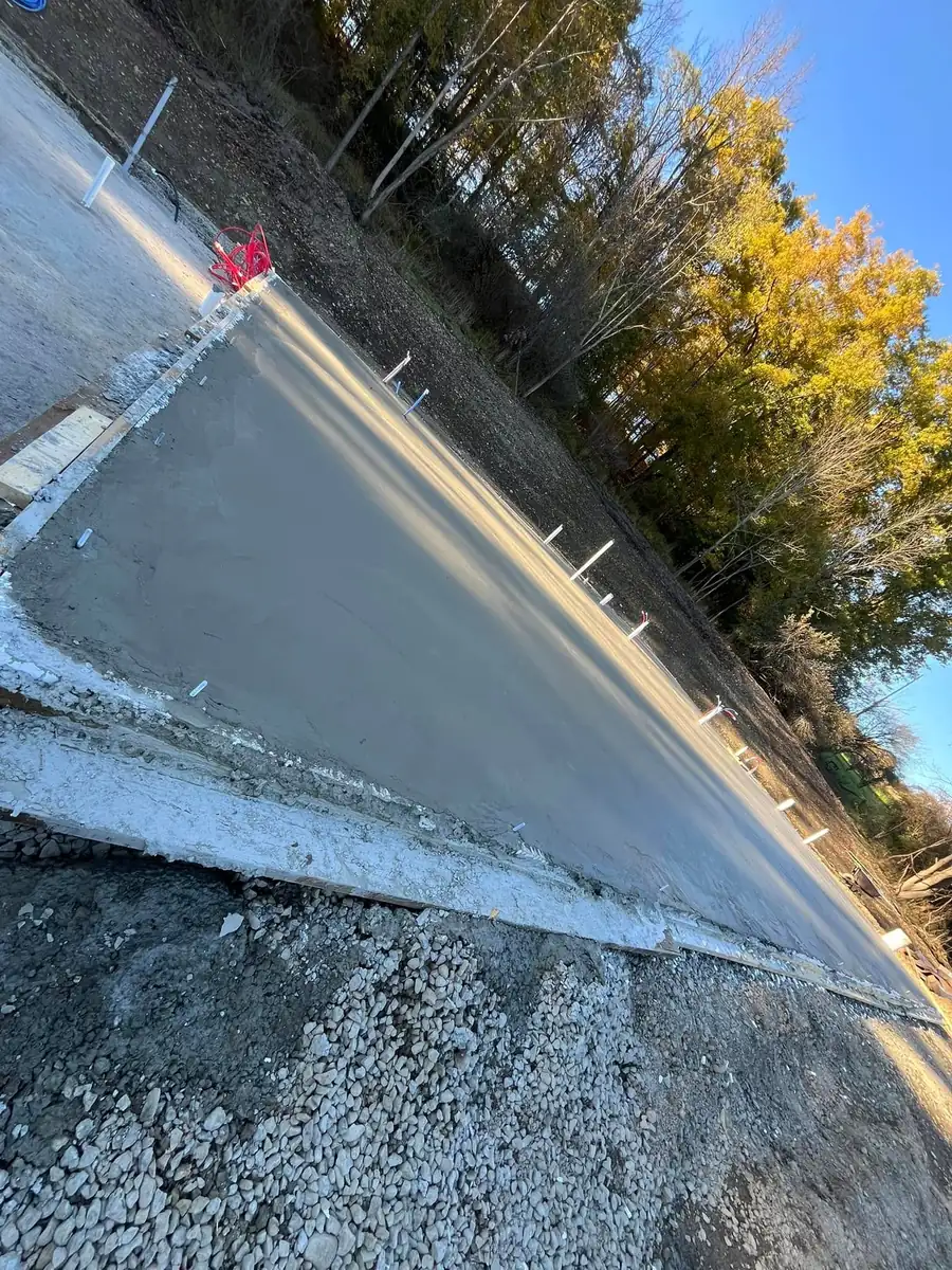 Edge of a freshly finished monolithic slab with fall trees behind