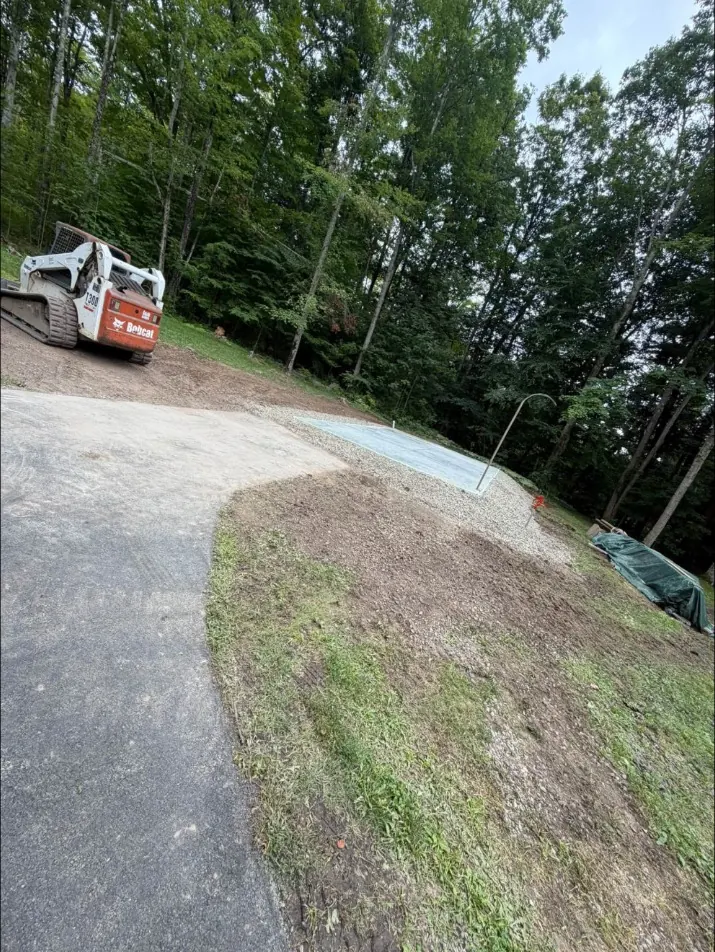 Track loader beside a finished monolithic slab and new gravel in Oxford, NY