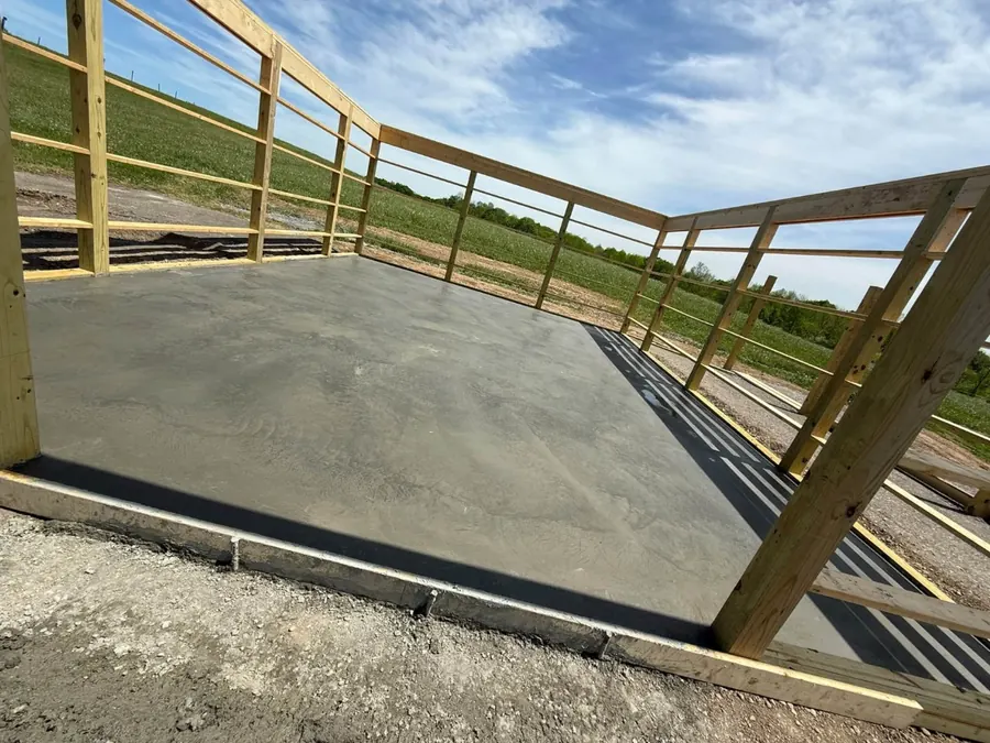 Smooth finished concrete floor inside a pole barn, seen from the corner
