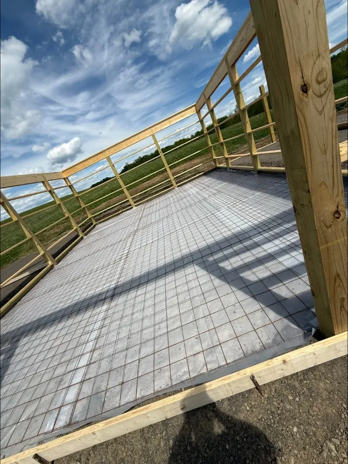 Wire mesh over a vapor barrier inside a pole barn frame before the pour