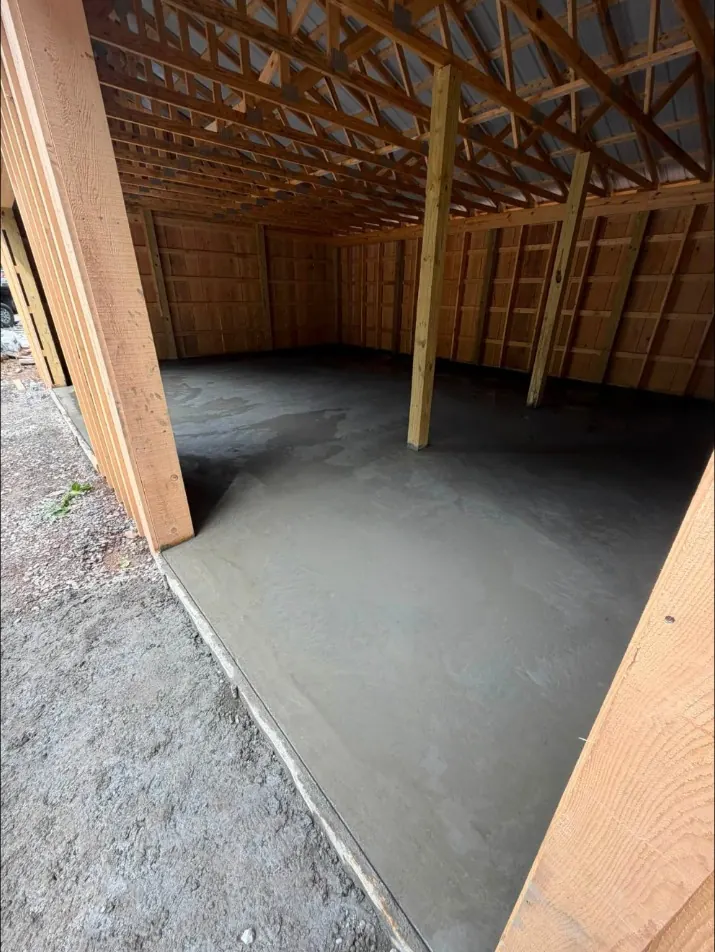 Fresh concrete floor inside a pole building with the doors open