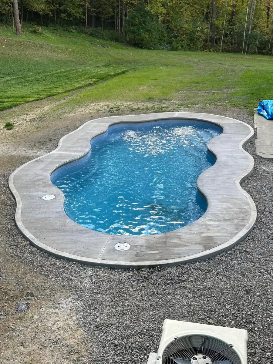 Inground pool with a stamped concrete coping and gravel surround