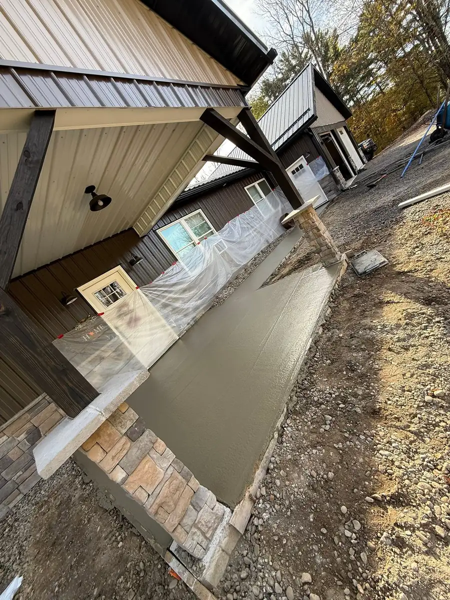 Concrete poured into forms under a covered porch