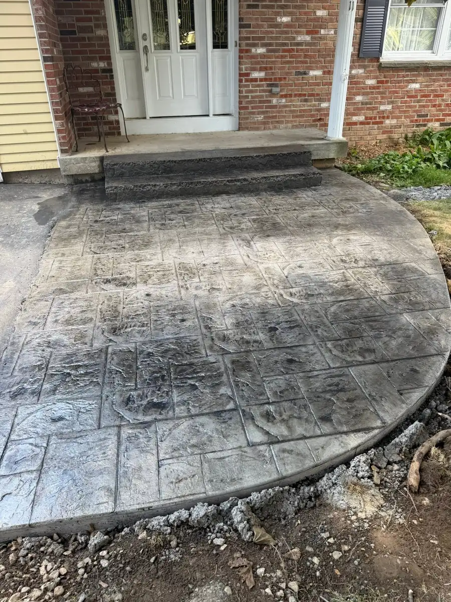 Ashlar slate stamped concrete entryway at the front steps of a brick house