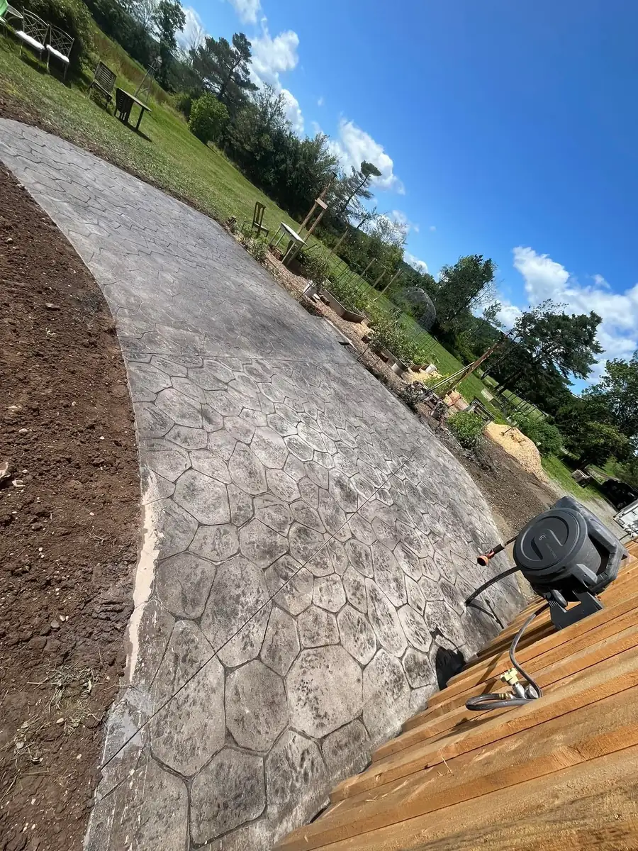 Curved stamped concrete walkway leading to a back deck