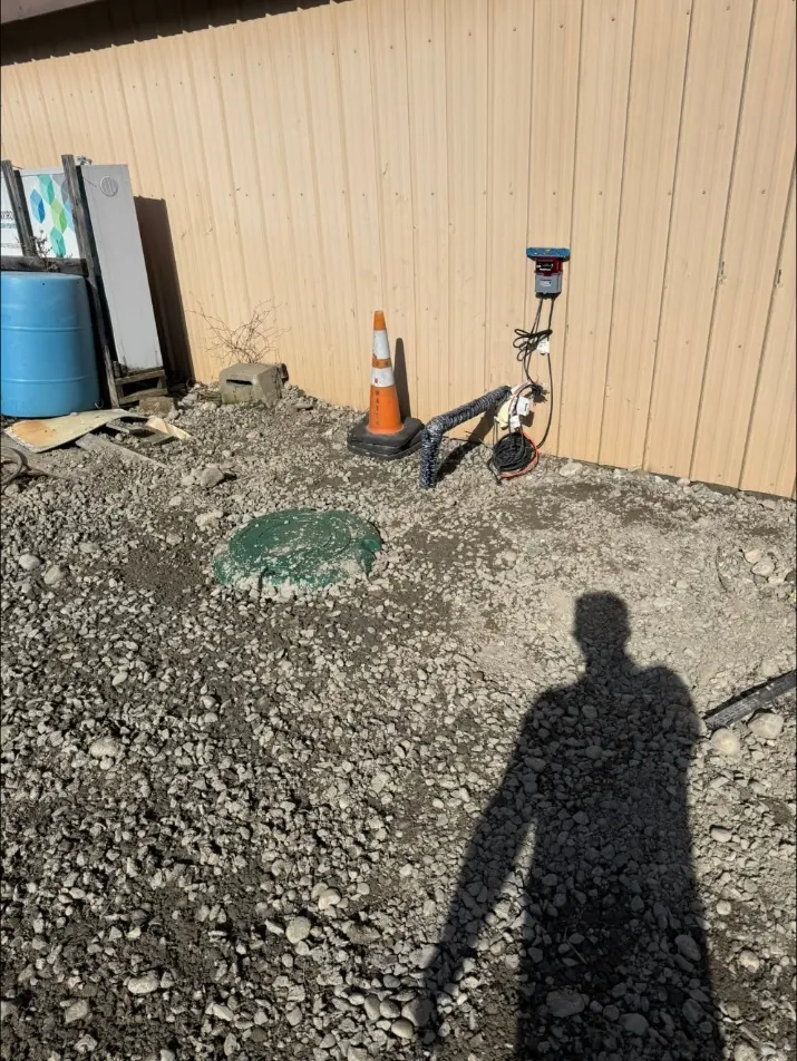 Backfilled tank riser beside a commercial building